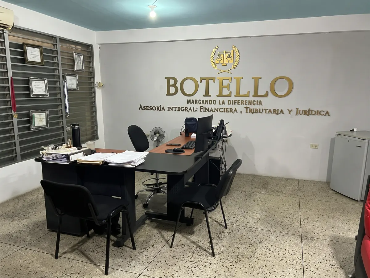Oficina de Botello & Asociados en San Antonio del Táchira, con el logo del despacho en la pared